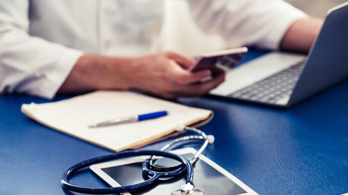 Bildet viser en hånd som holder i en mobiltelefon.