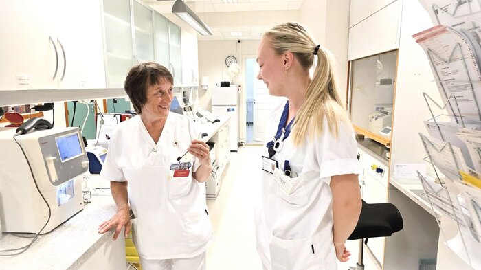 Bildet vider til sykepleiere som står på medisinrommet og snakker