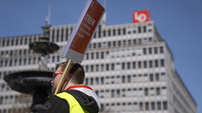 Bildet viser streikende mann med gul vest og plakat