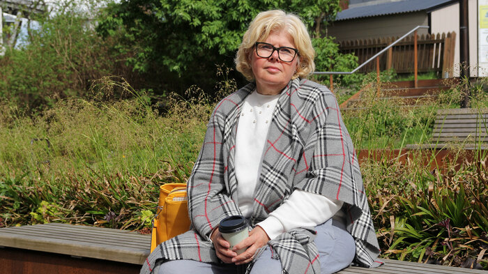 Bildet viser kreftoverleveren Ingunn Haugenes på en benk