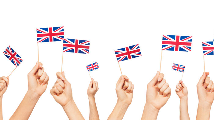 bildet viser hender som holder britisk flagg