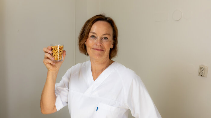 Bildet viser Liv Bjerke Rodal med et glass med peanøtter.