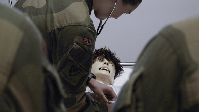 Bildet viser militært personell som undersøker simuleringsdukke