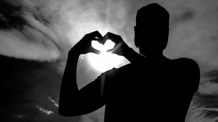 Bildet viser en mann som viser hjertesymbolet