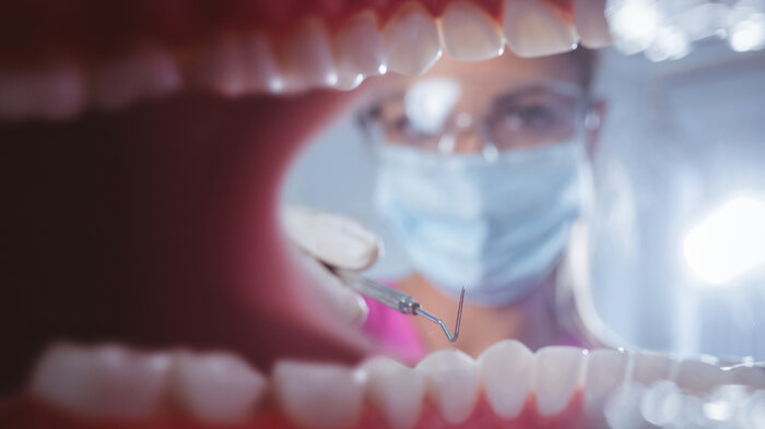 Bildet viser en munn og en tannlege.