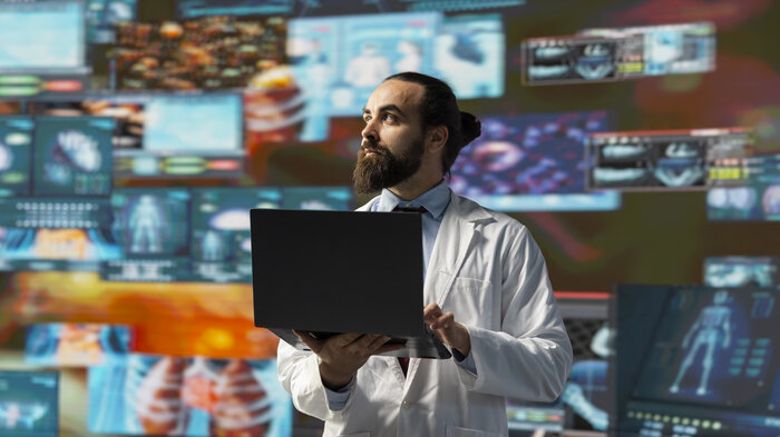 teknologiske ønsker bildet viser sykepleier med pc mot fargerike skjermer