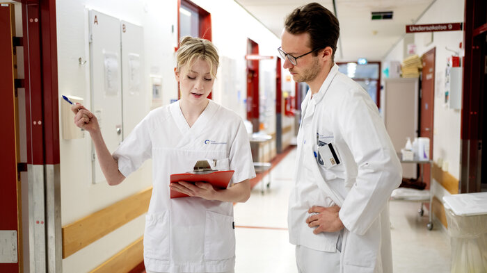 Bildet viser en sykepleier som diskuterer med en lege.