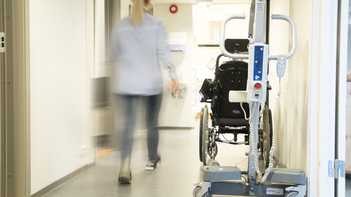 Bildet viser kvinne som går i korridor