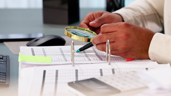 bildet viser en som gransker et papirdokument