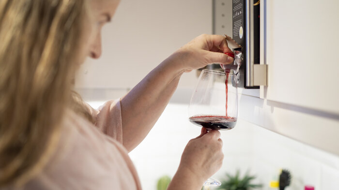 bildet av kvinne som tar et glass rødvin