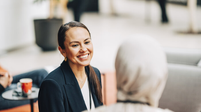 Bildet viser to kvinner som snakker sammen