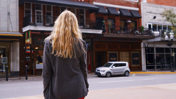 Bildet viser en kvinne som står med ryggen mot kamera.