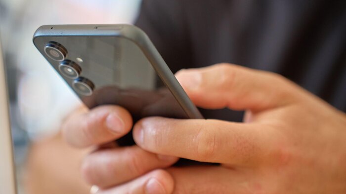 Bildet viser en mann som scroller på telefonen.