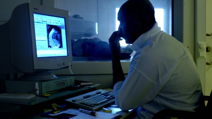 Bildet viser en radiolog som ser på røntgen