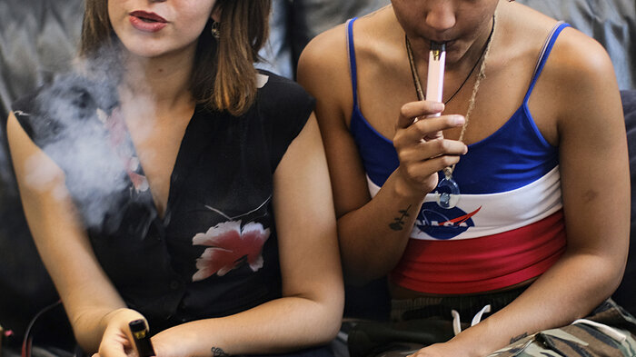 Bildet viser to unge jenter som vaper.