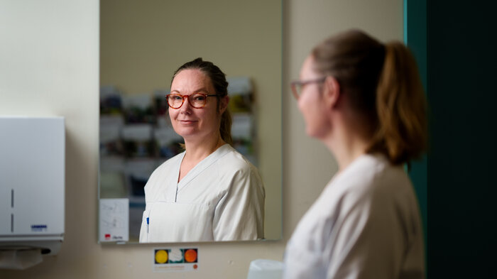 Bildet viser Lise Tuset Gustad som ser seg i et sykehusspeil.