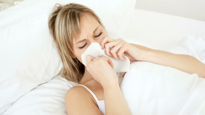 Syk dame ligger i sengen