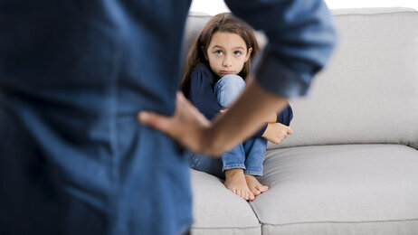 Engstelig barn kryper sammen i sofaen.