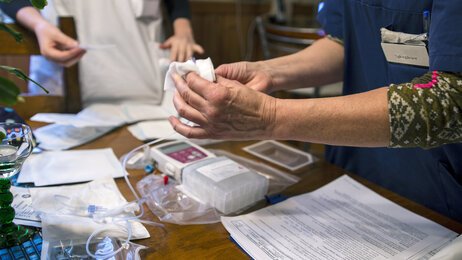 Bildet viser en sykepleier som gir en annen opplæring i bruk av epidural smertepumpe.