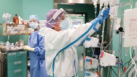 Bildet viser to sykepleiere på en sykehusstue.