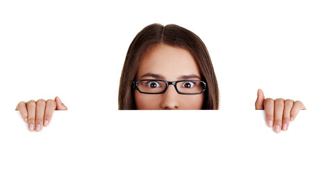 Bildet viser en kvinne med oppsperrede øyne som titter over en kant