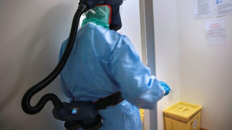 Bildet viser en intensivsykepleier med smittevernutstyr på jobb