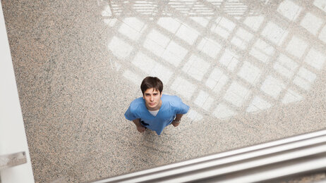 Bildet viser en sykepleier som titter opp mot kamera