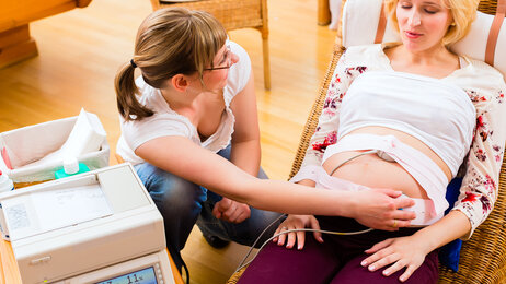 Bildet viser en gravid kvinne som blir undersøkt av jordmor