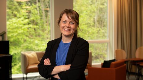 Bildet viser innleggsforfatter Aina Kolle. Hun smiler til kamera og holder armene i kors.