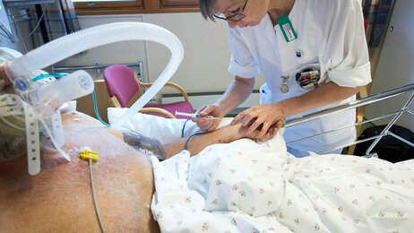 Sykepleier setter sprøyte på pasient, intensivavdelingen på Moss sykehus.