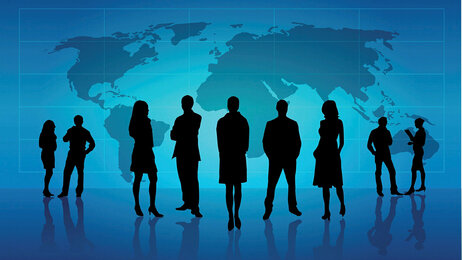 Silhuetter av folk som står foran et verdenskart