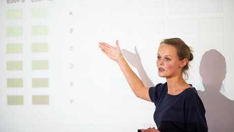 Bildet viser en som presenterer på en konferanse