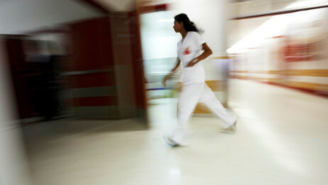 Sykepleier som løper og stresser.