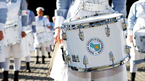 Bildet viser en tromme i forgrunnen og NSFs trommekorps i bakgrunnen.
