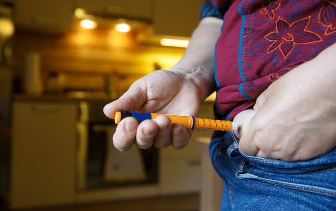 Bildet viser en person med diabetes som setter sprøyte