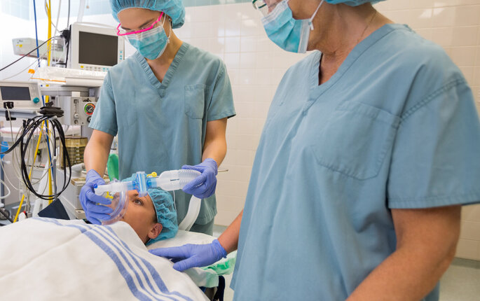 Bildet viser sykepleiere som forbereder en pasient for operasjon