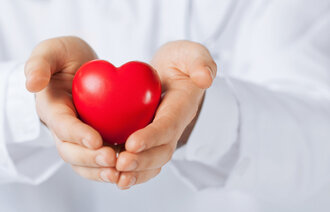 Bildet viser to hender som holder et hjerte.