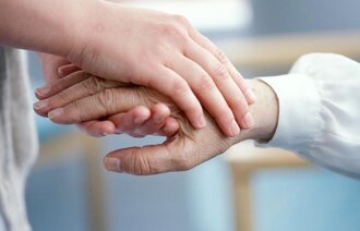 Bildet viser to hender som holder hverandre