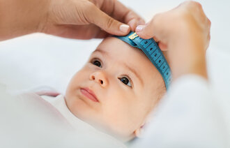 Bildet viser et spedbarn som blir målt