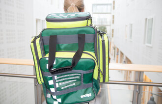 Bildet viser en sykepleier med en sekk.