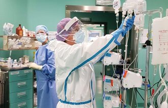 Bildet viser to sykepleiere på en sykehusstue.