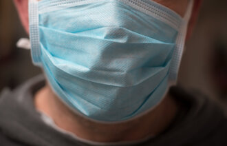  Bildet viser en mann med munnbind. 