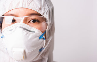 Bildet viser en helsearbeider med smittevernutstyr