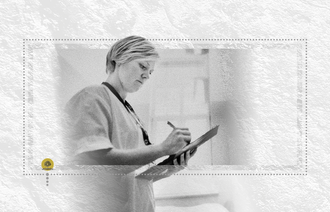 Bildet viser en sykepleier som skriver noe på et ark mens hun står oppe