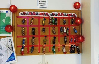 Bildet viser en julekalender laget på en oppslagstavle.