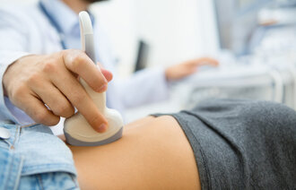 Bildet viser en kvinne som får ultralyd tidlig i svangerskapet