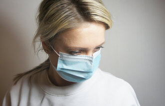 Bildet viser en kvinne med munnbind