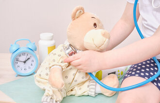 Jente bruker stetoskop på kosedyr