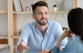 Bildet viser en mann og en kvinne som snakker sammen