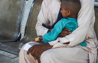 Bildet viser et barn som sitter på et fang.